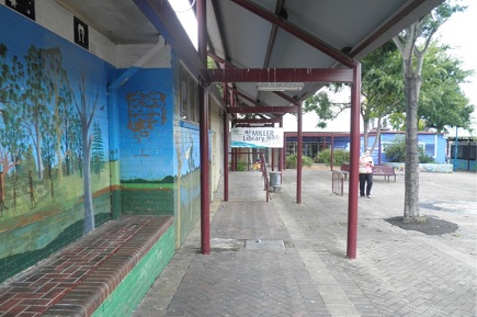 Outdoors at the Miller Community Centre, featuring a wall with a painted mural.  